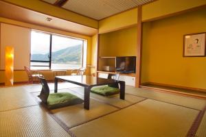 uma sala de estar com uma mesa e uma grande janela em Suigekka em Wakasa