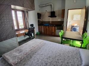 バンガロールにあるStudio Room in Bengaluruのベッドと机とテーブルのある寝室