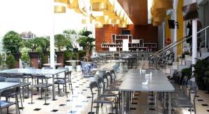 a restaurant with tables and chairs in a building at Grant Hotel Subang in Bandung