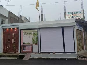 JāmbにあるShree DashbhujaNath Staysの巻き上げ式シャッター付きの窓がある建物