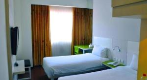 a hotel room with two beds and a television at Everbright Ambon Hotel in Ambon