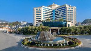 a large building with a fountain in the middle of a street at HELSTON HOTEL in Huadu