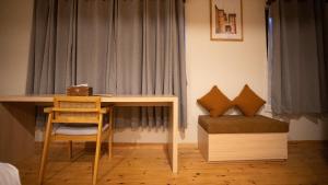 una habitación con un escritorio, una silla y una mesa en Hotel Oms Home, en Tukucha