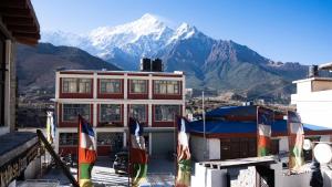 Un edificio con montañas al fondo con banderas. en Hotel Oms Home, en Tukucha