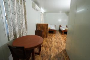 a small room with a table and chairs and a bed at Devi Palace Pattabiram in Tandurai