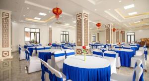 a banquet hall with blue and white tables and chairs at Doan Gia Resort in Phong Nha +221 photos