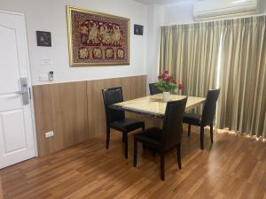a dining room table with chairs and a painting on the wall at Penthouse by JJ in Bangkok