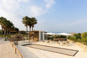 a patio with tables and chairs and umbrellas at Masseria del Carrubo in Noto