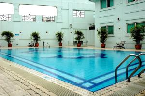 a large swimming pool in a building with plants at Hotel 81 Tristar in Singapore