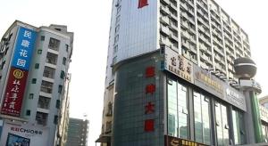 een hoog gebouw midden in een stad bij Sheng Lin Na Hotel Minzhi Branch in Shenzhen