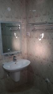 uma casa de banho com um lavatório e um espelho em Serapis Hotel em Ḩilf