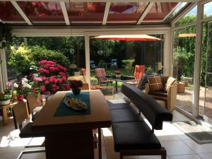 einen Wintergarten mit einem Tisch und Stühlen sowie eine Terrasse in der Unterkunft Bed & Breakfast Faas in Wittlich