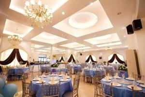 a banquet hall with blue tables and chairs and a chandelier at Islands Hotel in Roxas City +198 photos