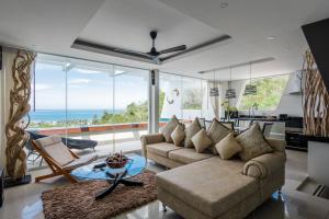 a living room with a couch and a table at Aqua Villas Seaview Chaweng Noi in Amphoe Koh Samui