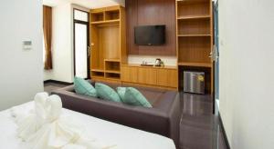 a living room with a couch and a flat screen tv at Thanburi Hotel in Udon Thani