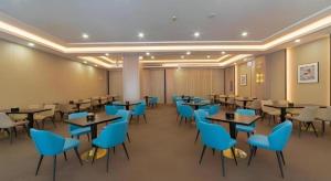 a dining room with tables and blue chairs at GreenTree Eastern Dali Railway Station Hotel in Dali