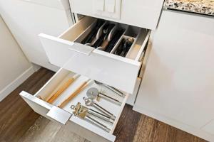 a drawer in a white cabinet filled with cooking utensils at CBD Apartment Pool 24-7 Gym Parking in Cincinnati