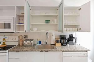 a kitchen with white cabinets and a sink at CBD Apartment Pool 24-7 Gym Parking in Cincinnati