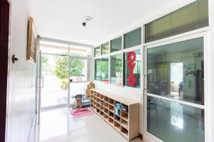 une grande pièce avec des portes vitrées et une étagère à livres dans l'établissement OYO 904 Mai Thai Place, à Hua Hin