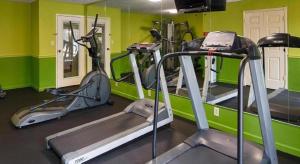 a gym with green walls and tread machines at Baton Rouge Hotel in Baton Rouge