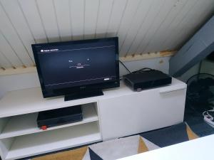 a flat screen tv on a white entertainment center at Gare pleinitude in Le Mans