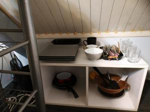 a shelf in a kitchen with utensils at Gare pleinitude in Le Mans