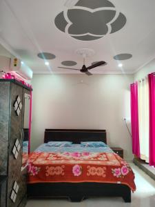 Un dormitorio con una cama con ventilador de techo. en Shiva Homestay, en Rishīkesh