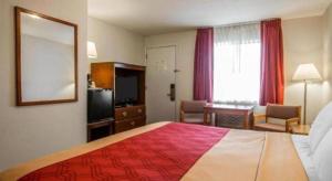 a hotel room with a bed and a mirror at Baymont by Wyndham Lake George in Lake George