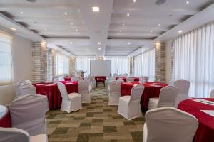 une salle de conférence avec des tables et des chaises rouges et blanches dans l'établissement Village Highland Resort, à Godāvari 30 autres photos