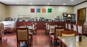アナーバーにあるComfort Inn & Suites University Southのテーブルと椅子とバーのあるレストラン