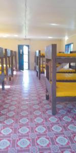 une pièce avec un sol recouvert de moquette et une pièce avec des bancs en bois dans l'établissement Sabeto Hostel, à Mba