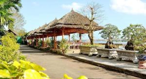 a pavilion with benches and a beach in the background at My Tra Riverside Hotel in An Bình (1)