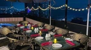 a table on a balcony with a view of the city at Hotel Tower Inn, Chittagong in Chittagong