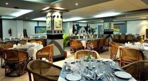 a restaurant with tables and chairs in a room at Hotel Tower Inn, Chittagong in Chittagong