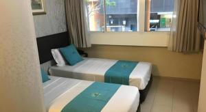 two beds in a hotel room with a window at 85 Beach Garden Hotel in Singapore +118 photos