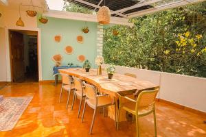 a dining room with a wooden table and chairs at Odd Table Stay and Experiences in Mandrem +84 photos