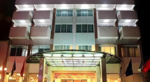 a tall building with a glass entryway in front of it at Huu Nghi Hotel in Hai Phong