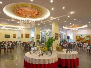 a banquet hall with tables and chairs and chandeliers at Huu Nghi Hotel in Hai Phong