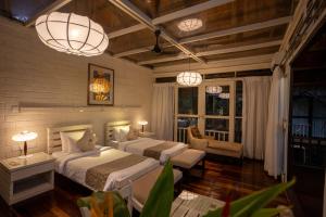 a bedroom with two beds and two chairs and lights at Jungle Village Unawatuna in Unawatuna +71 photos