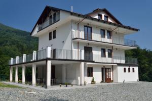 a white building with a balcony on a hill at Agriturismo Bastià in Corio