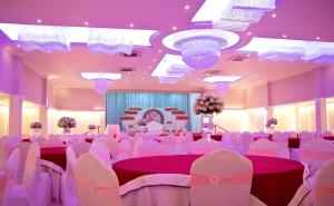 a banquet hall with pink tables and white chairs at Tilko Jaffna City Hotel in Jaffna