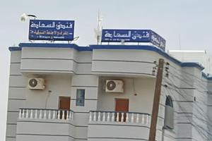 a building with two signs on top of it at فندق السعادة in Al Qarn
