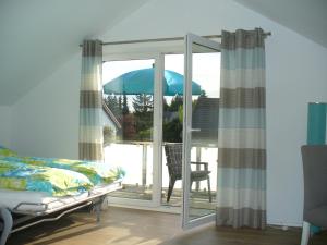 ein Schlafzimmer mit einem Bett und einem Sonnenschirm auf dem Balkon in der Unterkunft Ferienwohnung Rheinaue in Köln