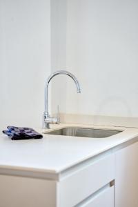 a white kitchen with a sink in a counter at Lavendel Apartments in Colonia Sant Jordi +55 photos
