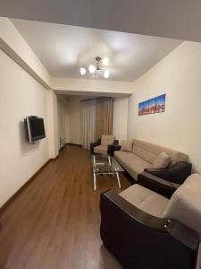 a living room with two couches and a tv at Pinko apartments in Yerevan