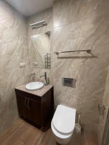 a bathroom with a white toilet and a sink at Pinko apartments in Yerevan +9 photos