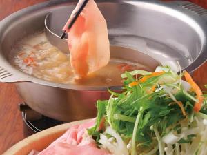 a pot of soup and a bowl of food at Sakuraan Kawaguchiko Hotel in Fujikawaguchiko