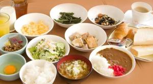 富山市にあるHotel Park Inn Toyamaのさまざまな種類の食べ物が入ったボウルが置かれたテーブル