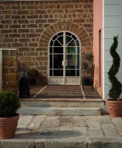 a brick building with a door leading to a garden at Relais Casa Mirabile in Menfi