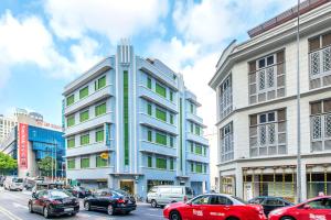 a tall building on a city street with cars at Hotel 81 Rochor in Singapore